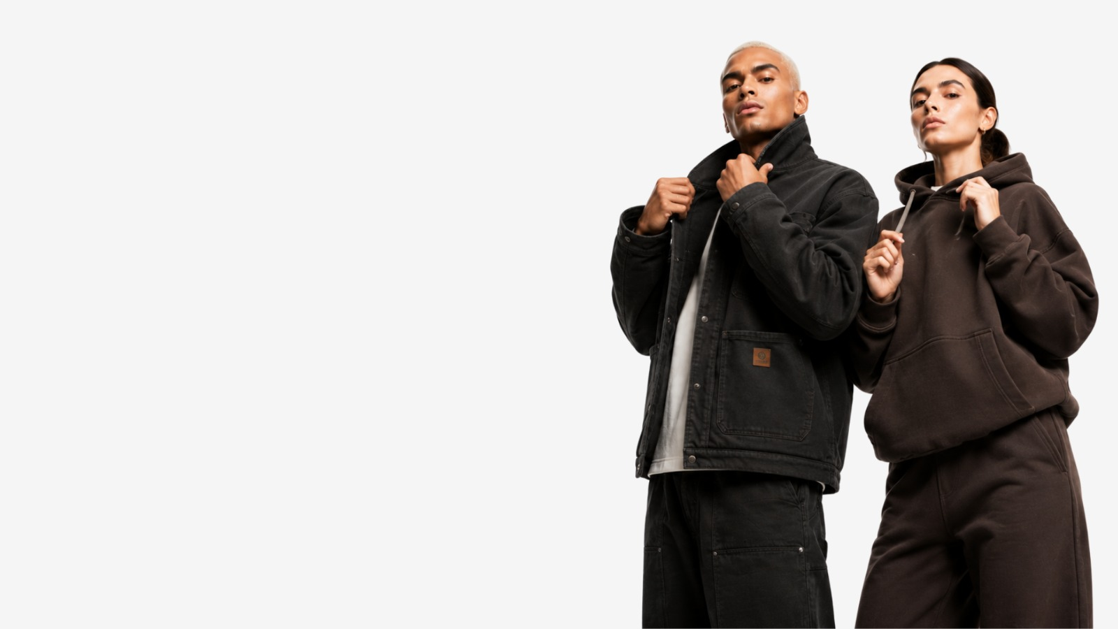 Two models wearing a black work jacket and a brown fleece hoodie made by Safir Wear