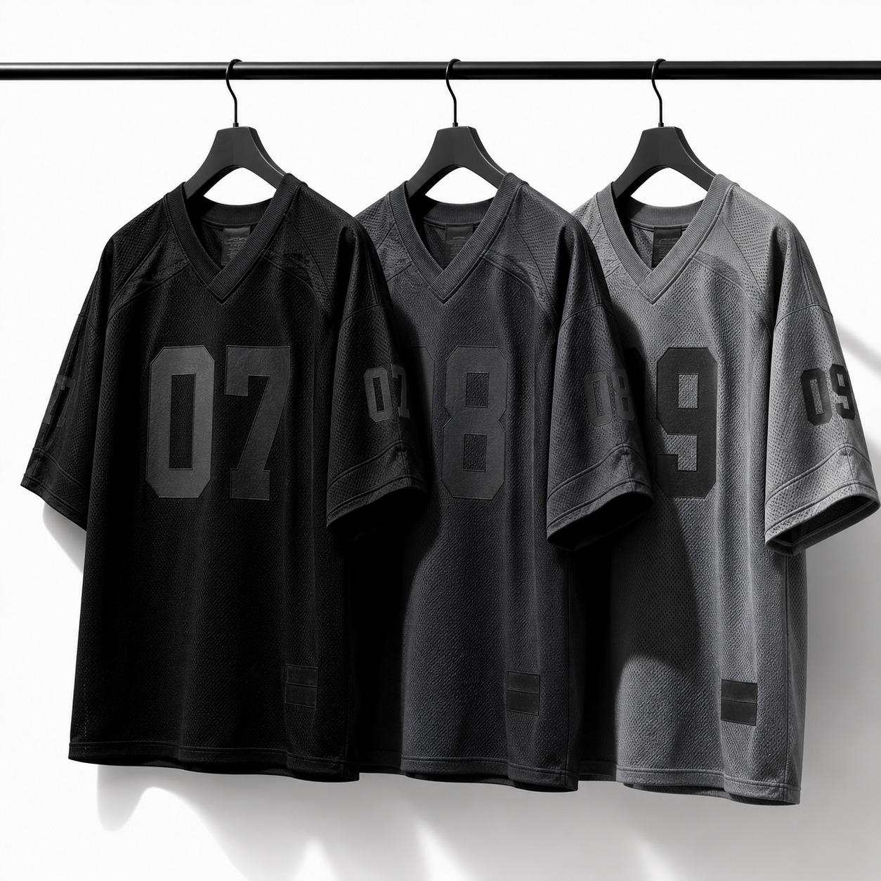 Numbered team jerseys in black, charcoal and grey — custom team kits by Safir Wear